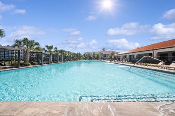 Infinity-edge olympic-size swimming pool with tanning deck & private cabanas